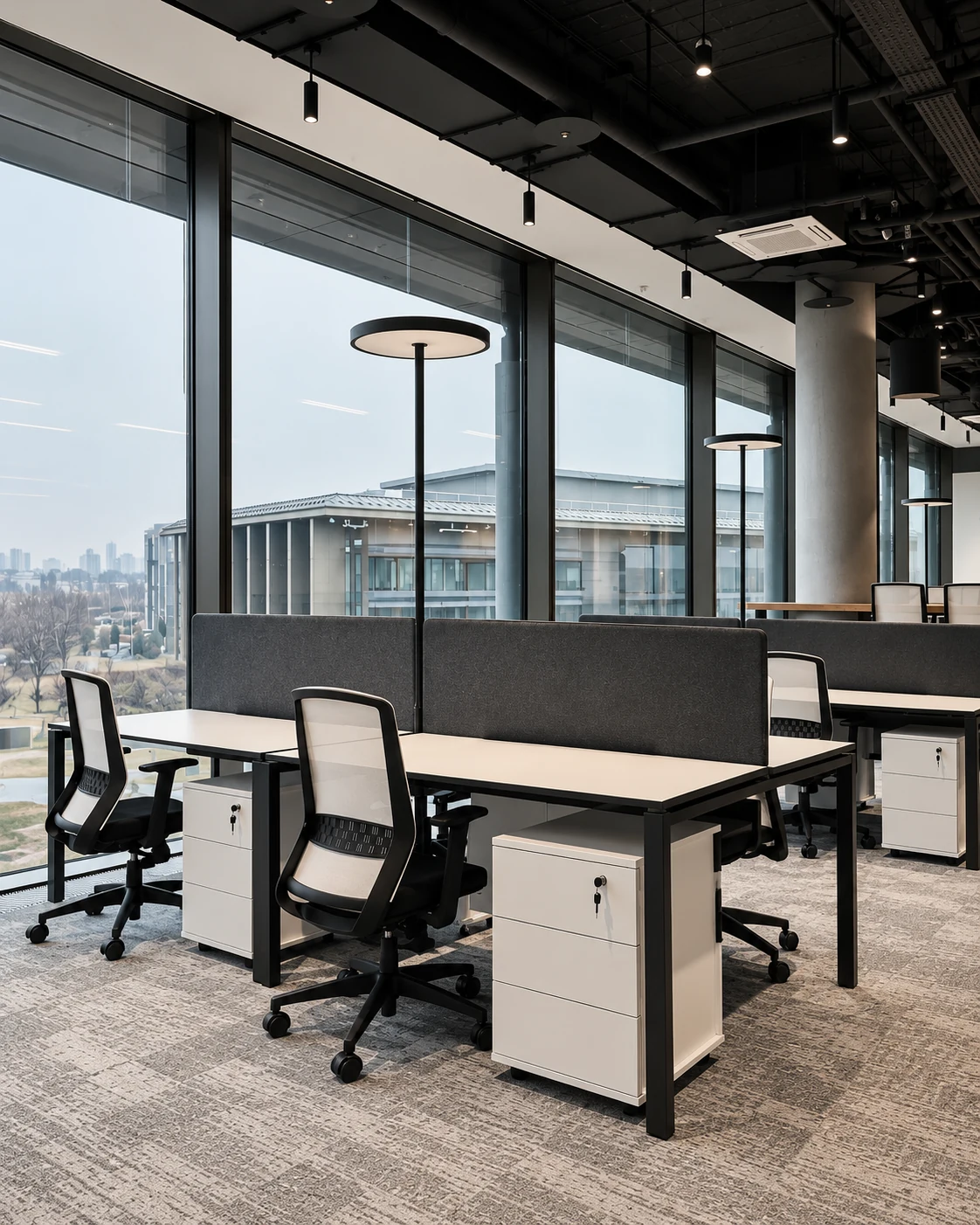 Daylit shared office with round-headed floor lamps